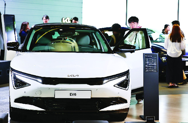 기아 ‘더 뉴 EV6’가 공개된 지난 13일 관람객들이 서울 강남구 기아360에서 차량을 살펴보고 있다. 기아는 더 뉴 EV6에 신규 패밀리룩 ‘스타맵 시그니처 라이팅’을 반영한 주간 주행등(DRL)을 적용했다. 뉴시스