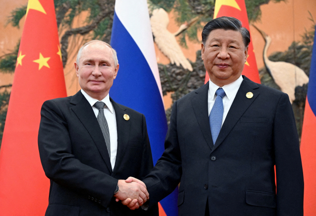 블라디미르 푸틴 러시아 대통령이 2023년 10월 18일 중국 베이징에서 열린 일대일로 포럼에서 시진핑 중국 국가주석과 악수를 하고 있다. 로이터연합