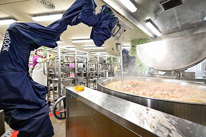 전국에서 처음으로 급식 로봇 ‘숭바삭’이 배치된 서울 성북구 숭곡중에서 로봇이 급식용 치킨을 튀기고 있다. 서울시교육청은 30억 원을 들여 학교 15곳에 로봇팔 설치를 지원할 계획이다. 사진공동취재단