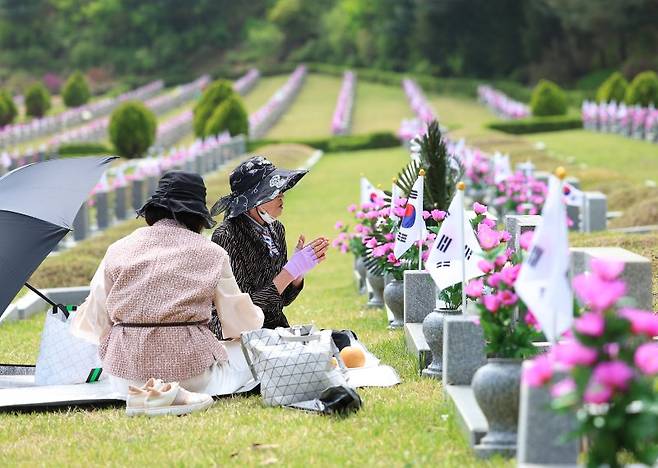 지난달 19일 서울 강북구 국립4.19 민주묘지를 찾은 4·19 혁명 유공자 가족이 묘소를 정리한 뒤 시간을 보내고 있다. 연합뉴스