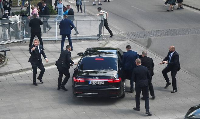 로베르트 피초 슬로바키아 총리가 15일(현지시각) 슬로바키아 중부 한들로바에서 총격을 당한 직후 보안 요원들이 그를 차에 태우고 있다. 한들로바/로이터 연합뉴스
