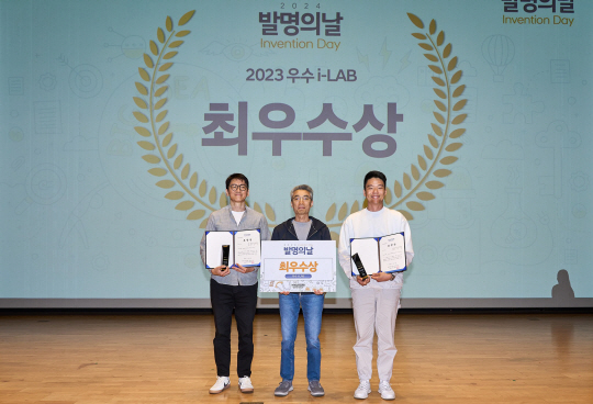 현대차·기아 ‘2024 발명의 날’ 행사 최우수 i-LAB 수상자 현대자동차·기아가 16일 경기 화성 남양연구소에서 주최한 사내 특허 경연대회 ‘2024 발명의 날’ 행사에서 최우수 i-LAB에 선정된 2개 부문 수상자가 기념 사진을 찍고 있다. 박상도 배터리성능기술개발팀 책임연구원(좌측), 송창현 현대차·기아 AVP본부 사장(가운데), 정성빈 열에너지시스템설계팀 책임연구원. 현대자동차·기아 제공.