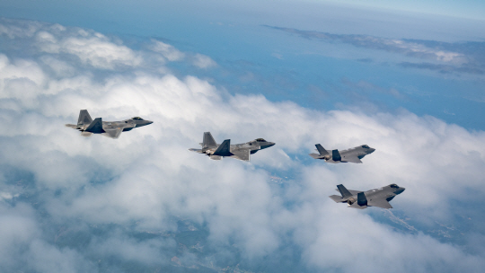 한국 공군 스텔스전투기  F-35A 2대(오른쪽) 미 공군의 세계 최강 F-22 랩터 2대(왼쪽)가 16일 오전 중부지역 상공에서 5세대 전투기 간 근접 공중전투기동훈련인 ‘도그파이트(Dogfight)’를 펼치기 앞서 구름 속을 비행하고 있다. 공군 제공