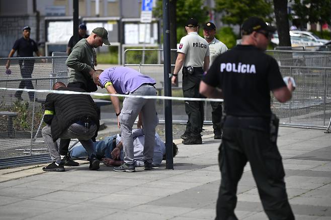 15일(현지시간) 슬로바키아의 한들로바에서 로베르트 피초(59) 슬로바키아 총리가 총격을 받은 후, 보안 요원들이 총격 용의자를 체포하고 있다. [AFP]