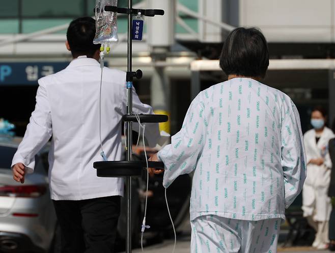 의사들의 집단행동이 이어지고 있는 9일 종로구 서울대학교병원에 한 환자가 의료진 옆을 지나고 지나고 있다. ⓒ연합뉴스
