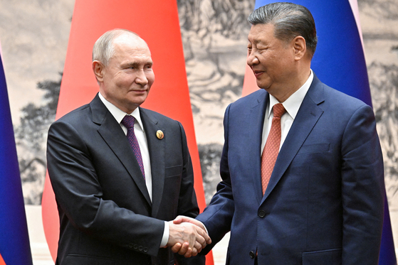 블라디미르 푸틴 러시아 대통령이 지난 16일 중국 베이징에서 열린 회담에서 시진핑 중국 국가주석과 악수하고 있다. 〈사진=로이터〉