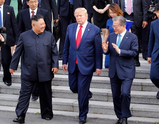 문재인(오른쪽) 전 대통령과 김정은(왼쪽) 북한 국무위원장, 도널드 트럼프 전 미국 대통령이 2019년 6월 30일 판문점 자유의집 앞에서 만나 나란히 걸어가고 있다. 판문점=AP 연합뉴스