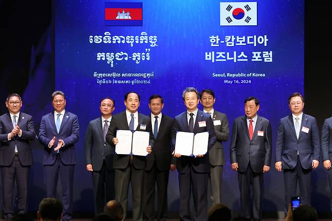 Daewoo E&C CEO Baek Jeong-wan (sixth from left) and WorldBridge Group Chairman Rithy Sear (fourth from left), along with South Korean Industry Minister Ahn Duk-geun (seventh from left) and other officials, attend an MOU signing event held during the Cambodia-Korea business forum at the Korea Chamber of Commerce and Industry, Seoul, Thursday. (Daewoo E&C)