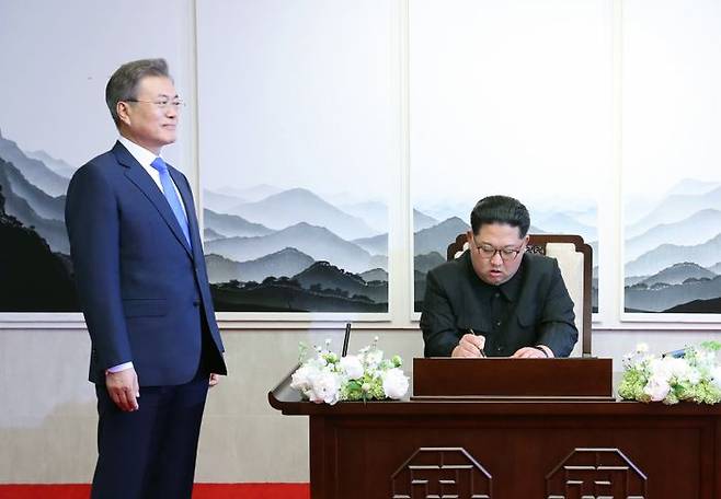 북한 김정은이 지난 2018년 4월 27일 판문점 평화의 집에서 문재인 전 대통령이 곁에 시립해있는 가운데, 방명록에 서명을 하고 있다. ⓒ뉴시스