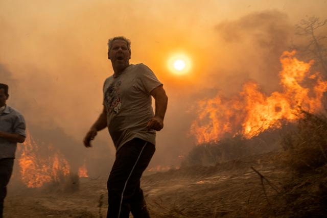 지난해 7월 25일 그리스 남동부 로도스섬에서 발생한 산불을 피해 마을 주민들이 대피하고 있다. 당시 그리스에서는 섭씨 40도를 웃도는 폭염이 이어졌다. AP 연합뉴스 자료사진