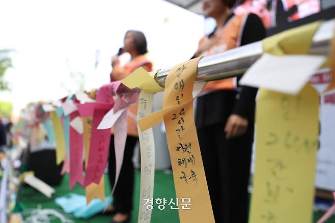전국장애인차별철폐연대 활동가들이 지난 4월 18일 서울 영등포구 63컨벤션센터 인근에서 제23회 장애인차별철폐의 날 기념식을 열고 있다. 연단에 ‘발달장애인 24시간 지원체계 구축’을 촉구하는 띠가 걸려 있다. 정효진 기자