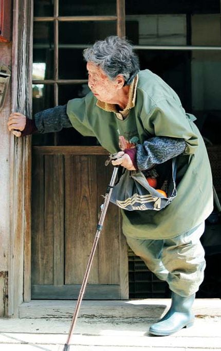 자택에서 지팡이를 짚고 힘겹게 걸어나오는 한 일본 노인. 일본에서 고령화가 급속도로 진행되면서 한평생 성실하게 일했어도 은퇴 후 저축에만 의존해 생활해야 하는 세월이 길어진 탓에 하루아침에 빈곤층으로 전락하는 ‘노후 파산’이 사회문제가 되고 있다. /블룸버그