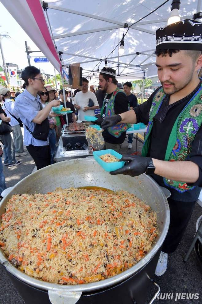 우즈베키스탄 요리사가 19일 성북구 성북동에서 제 16회 성북세계음식축제 누리마실에서 우즈베키스탄 전통음식인 양고기볶음밥을 선보이고 있다.