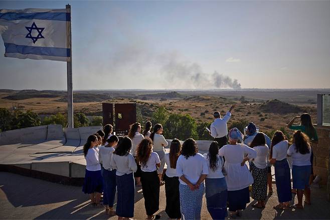 [스데로트=AP/뉴시스] 이스라엘 현충일인 13일(현지시각) 이스라엘 남부 스데로트의 관광지를 방문한 사람들이 가자지구에서 폭발이 일어난 후 연기가 치솟는 것을 지켜보고 있다. 2024.05.14.