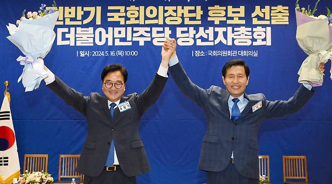 더불어민주당 국회의장 후보로 선출된 우원식 후보(왼쪽)와 국회부의장 후보로 선출된 이학영 후보가 16일 오전 국회 의원회관에서 열린 제22대 전반기 국회의장단 후보 선출을 위한 당선자 총회에서 꽃다발을 들고 두 팔을 들어 올리고 있다. 이상섭 기자