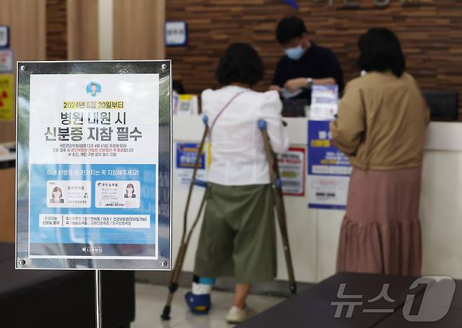 건강보험 본인확인 의무화 제도가 시행된 20일 오전 서울 동작구 한 병원에서 시민들이 접수를 하며 신분증을 보여주고 있다. 2024.5.20/뉴스1 ⓒ News1 김민지 기자