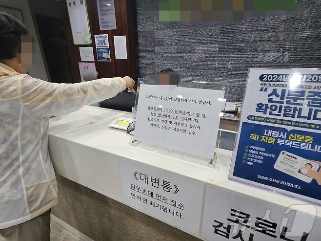 20일 강원 춘천 소양동의 한 병원에서 한 환자가 직원에게 신분증을 전달하고 있다.2024.5.20 한귀섭 기자