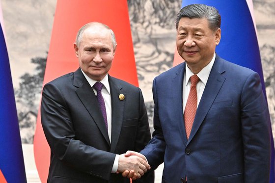 중국을 국빈방문한 블라디미르 푸틴 러시아 대통령(왼쪽)이 시진핑 중국 국가주석과 지난 16일 회담 중 악수를 나누고 있다. AFP=연합뉴스