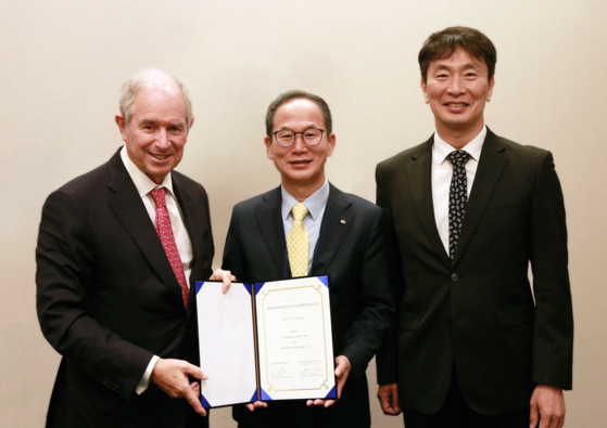 From left: Blackstone Co-founder, Chairman and CEO Stephen A. Schwarzman, KB Financial Group Chairman Yang Jong-hee and Financial Supervisory Service Gov. Lee Bok-hyun pose for a photo during a signing ceremony on Thursday in New York. [KB FINANCIAL GROUP]