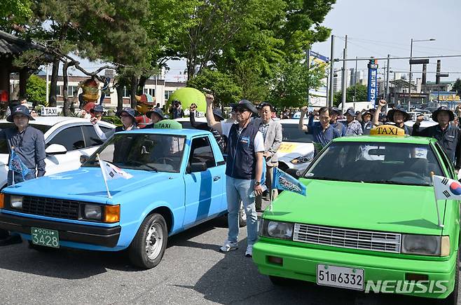 [광주=뉴시스] 박기웅 기자 = 제44주년 5·18민중항쟁 민주기사의 날 기념식이 열린 20일 오후 광주 북구 옛 무등경기장 앞에서 택시기사들이 구호를 외치고 있다. 이들은 44년 전 5·18민주화운동 당시 전남도청 앞 금남로를 가득 메우고 광주시민들의 저항을 촉발한 차량 행렬 시위를 재현했다. 2024.05.20. pboxer@newsis.com