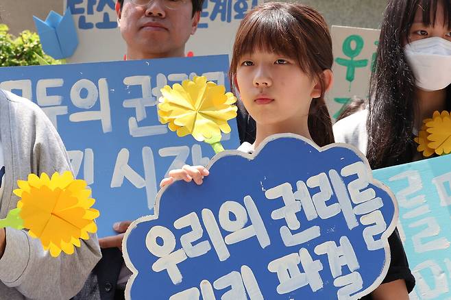 한국 정부의 기후 변화 대응이 헌법에 합치하는지를 묻는 기후위기 헌법소원 두 번째 공개 변론이 열린 21일 오후 서울 종로구 헌법재판소 앞에서 아기기후소송 최종 진술자로 나선 한제아양이 손팻말을 들고 있다. 백소아 기자 thanks@hani.co.kr