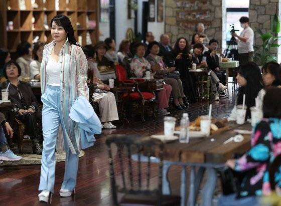 지난 4월 서울 강남의 한 베이커리카페에서 열린 ‘설영희 마리에블랑 부띠끄’ 패션쇼에서 한 시니어 모델이 워킹을 하고 있다. 연합뉴스