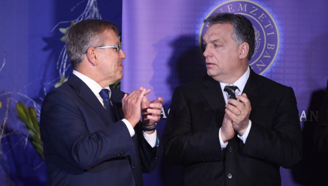 죄르지 마톨치(왼쪽) 헝가리 중앙은행장과 오르반 빅토르 헝가리 총리가 한 행사장에 참석해 박수를 치는 도중 서로를 응시하고 있다.  bne 인텔리뉴스 캡처