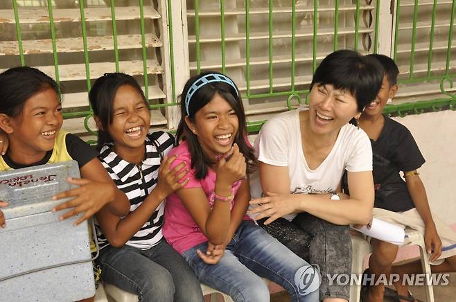 필리핀 아이들과 한비야 2013년 필리핀 태풍 임시난민수용소 학교에서 아이들과 얘기하면서 활짝 웃는 한비야 
[본인 제공]