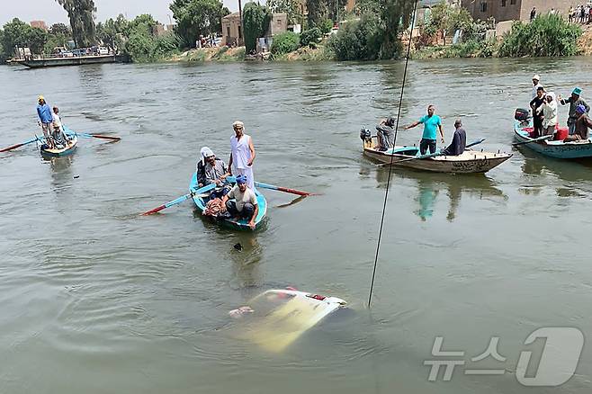 이집트 나일강 인근 주민들이 보트를 타고 물에 빠진 미니버스 승객들을 구하고 있다. ⓒ AFP=뉴스1