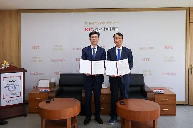 김태상 경남정보대학교 총장(왼쪽)과 김용근 ㈜아이언모터스 회장이 협약서를 들고 포즈를 취하고 있다. 경남정보대 제공