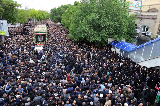 21일(현지시간) 이란 타브리즈시에서 열린 장례식에서 지난 19일 헬기 추락으로 사망한 에브라힘 라이시 이란 대통령 등의 시신을 실은 트럭에 몰려든 추모자들. [AP=연합뉴스]