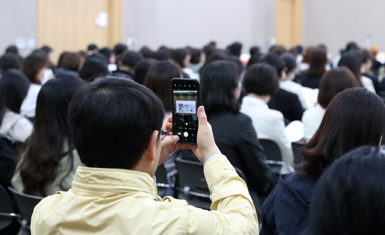 지난달 2일 대구 북구에서 열린 종로학원의 의대 입시 설명회에서 한 학부모가 휴대전화 카메라로 설명회 자료를 촬영하고 있다. 뉴스1