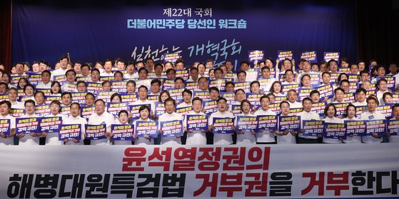 22일 충남 스플라스리솜에서 열린 제22대 국회 더불어민주당 당선인 워크숍에서 이재명 대표와 박찬대 원내대표, 당선인들이 피켓을 들고 구호를 외치고 있다. 연합뉴스