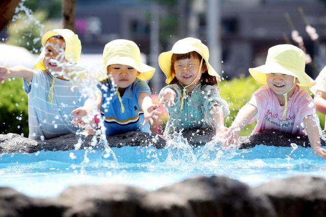 ▲ 초여름 날씨를 보인 지난 21일 광주 북구청 광장으로 야외활동 나온 북구청직장어린이집 아이들이 물레방아 연못에서 물놀이하며 즐거워하고 있다. 연합뉴스