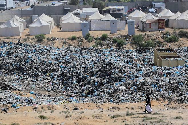 21일(현지시간) 가자지구 누세라이트 난민촌의 쓰레기 더미에서 한 주민이 쓸 만한 물건을 찾고 있다. AFP연합뉴스