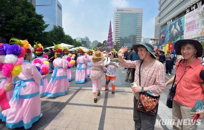 22일 서울 청계광장에서 전국단오제연합 주최로 열린 '단오, 단 하나가 되다' 행사에서 외국 관광객이 행렬을 향해 반갑게 손을 흔들고 있다.