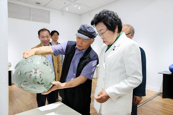 김경희 이천시장(오른쪽)이 작품전에 전시된 도자명장의 도자기를 둘러보고 있다. 이천시 제공