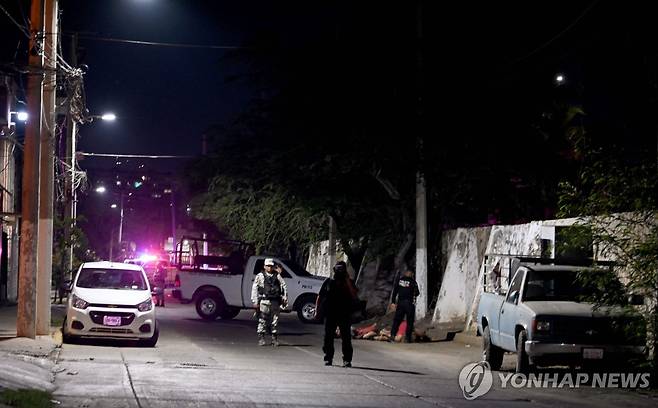 범죄 현장 살피는 멕시코 경찰 (아카풀코 AFP=연합뉴스) 20일 밤(현지시간) 멕시코 아카풀코에서 경찰이 살인 사건 현장에 출동해 주변을 살피고 있다. 2024.5.22