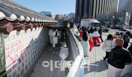 문화재청 관계자들이 지난해 12월 서울 종로구 경복궁 서쪽 담장에 새겨진 낙서 제거작업을 하고 있다. (사진=뉴스1)
