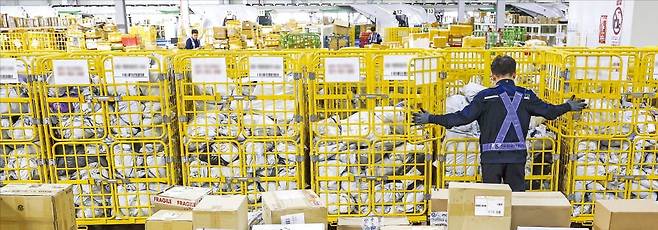 < 세관에 쌓여있는 직구제품들 > 16일 인천공항본부세관에서 특송물류센터 직원이 중국에서 배송된 해외 직구 화물을 정리하고 있다. 세관에 쌓여 있는 포장 화물은 관세 체납 등의 이유로 세관을 통과하지 못한 제품이다. /최혁 기자