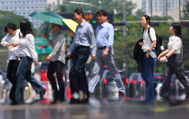 People cross a street in Seoul on Thursday. (Yonhap)