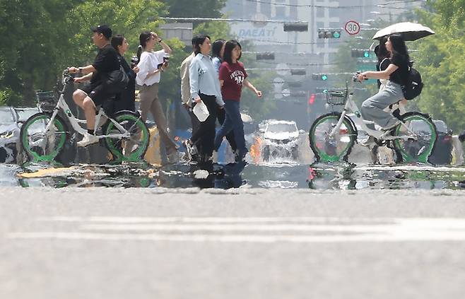 초여름 날씨를 보인 22일 오후 서울 영등포구 여의도공원 인근 도로에서 지열에 의한 아지랑이가 피어오르고 있다. [출처 : 연합뉴스]