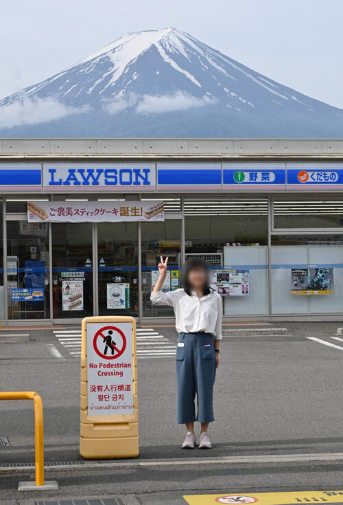 이젠 못 찍어요 일본을 찾은 한 관광객이 21일 후지산이 보이는 야마나시현 가와구치코정의 편의점 앞에서 기념 촬영을 하고 있다. 가와구치코=AFP연합뉴스