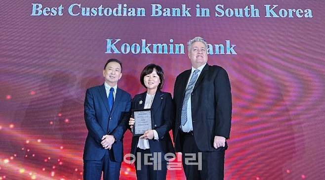 지난 23일 홍콩에서 진행된 아시아뱅커지 주관 ‘The Asian Banker Financial Markets Awards 2024’에서 김옥자(왼쪽 두번째) KB국민은행 수탁사업부장과 아시안뱅커지 관계자들이 기념사진을 촬영하고 있다. (사진=국민은행)