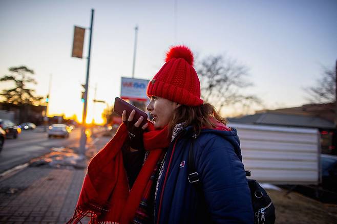 캐나다 온타리오주 나이아가라폴스의 한 호텔 밖에서 친구를 기다리며 음성 메시지를 보내고 있는 여성. / 로이터