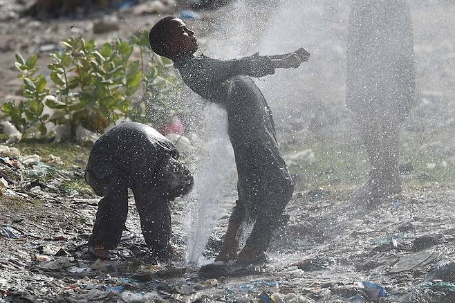 21일(현지시간) 파키스탄의 남부 카라치에서 사람들이 물놀이를 하고 있다. 사진=EPA 연합뉴스