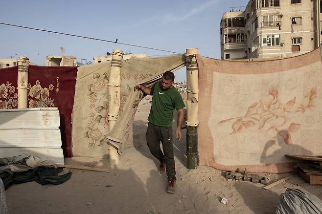 5월22일 가자지구 남부 칸유니스로 피란을 온 주민이 이스라엘군이 쏜 포탄 탄피를 기둥 삼아 세운 임시 거처를 나서고 있다. EPA 연합뉴스