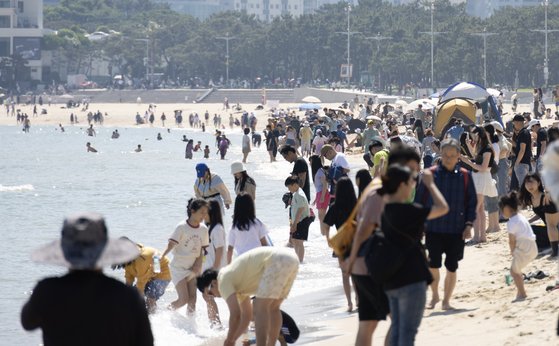 맑은 초여름 날씨를 보인 19일 오후 부산 해운대구 해운대해수욕장을 찾은 시민들이 더위를 식히고 있다. 연합뉴스