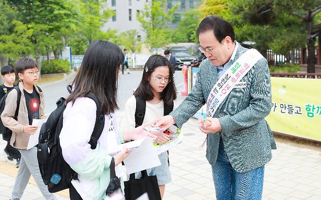 서거석 전북교육감이 24일 오전 전주 화정초에서 진행된 학교폭력 예방을 위한 등굣길 캠페인에서 학생들에게 관련 홍보물을 나눠주고 있다. 전북교육청 제공