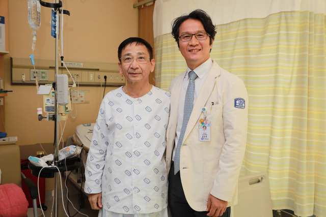 홍성후(오른쪽) 서울성모병원 비뇨의학과 교수가 하대정맥혈전 동반 신장암을 앓았던 베트남 환자 레 쟝반씨와 퇴원을 앞두고 기념촬영을 했다. 사진 제공=서울성모병원